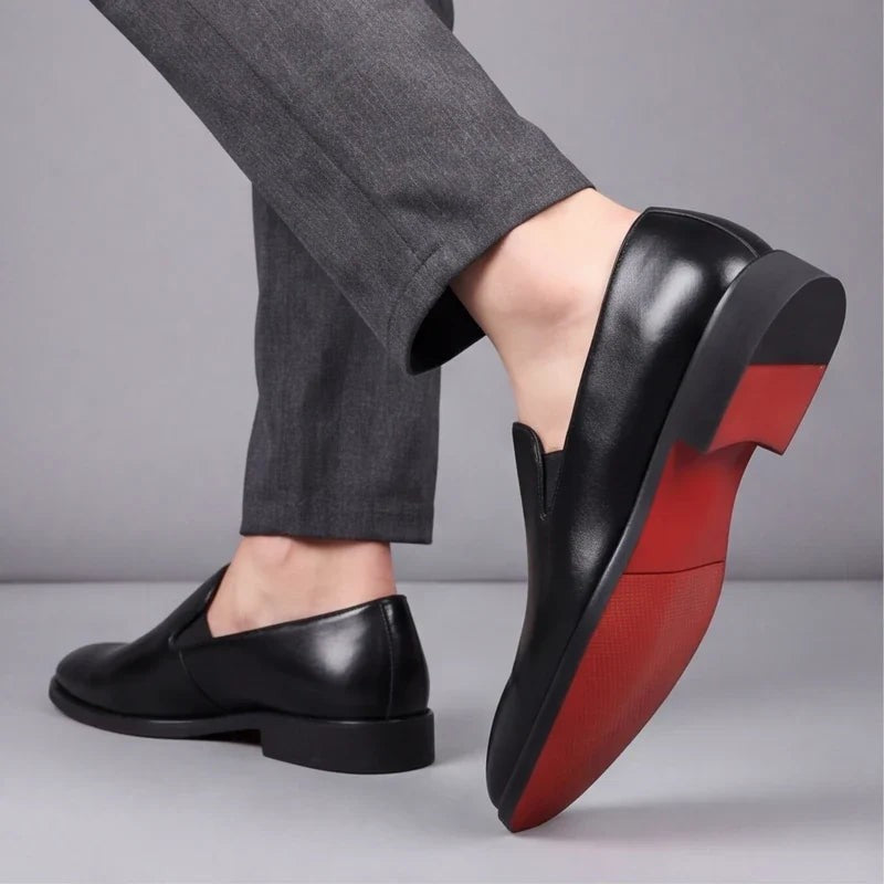 Model showing red sole detail on black leather slip-on loafer