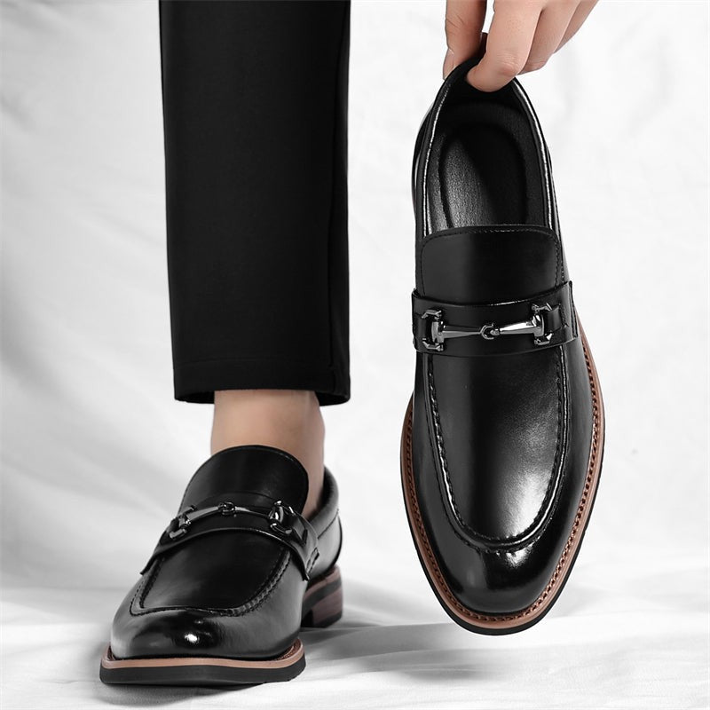 Model stepping in black leather loafers with silver buckle accent