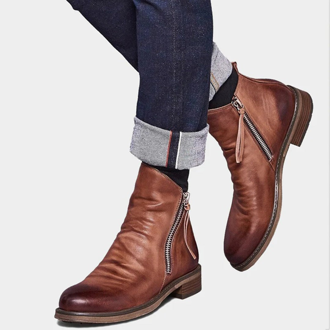 Man wearing brown leather zip-up boots with turned-up denim jeans