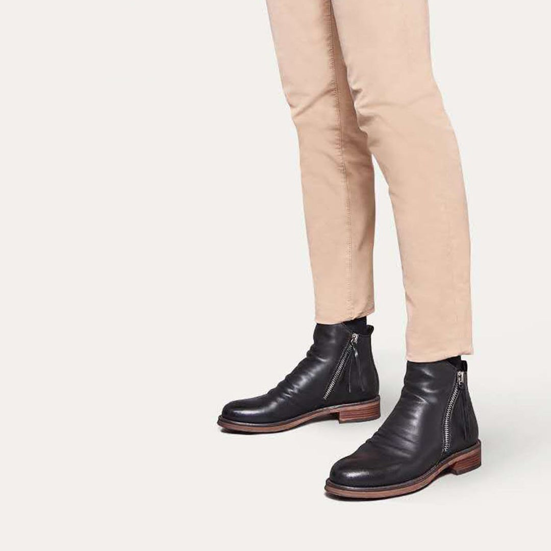 Black leather zip boots worn with rolled-up beige chinos