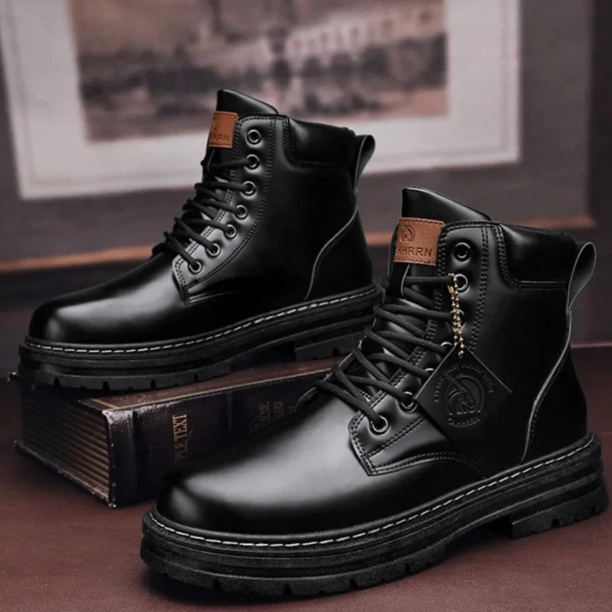 Black leather ankle boots paired together, showing rugged tread and lace detailing