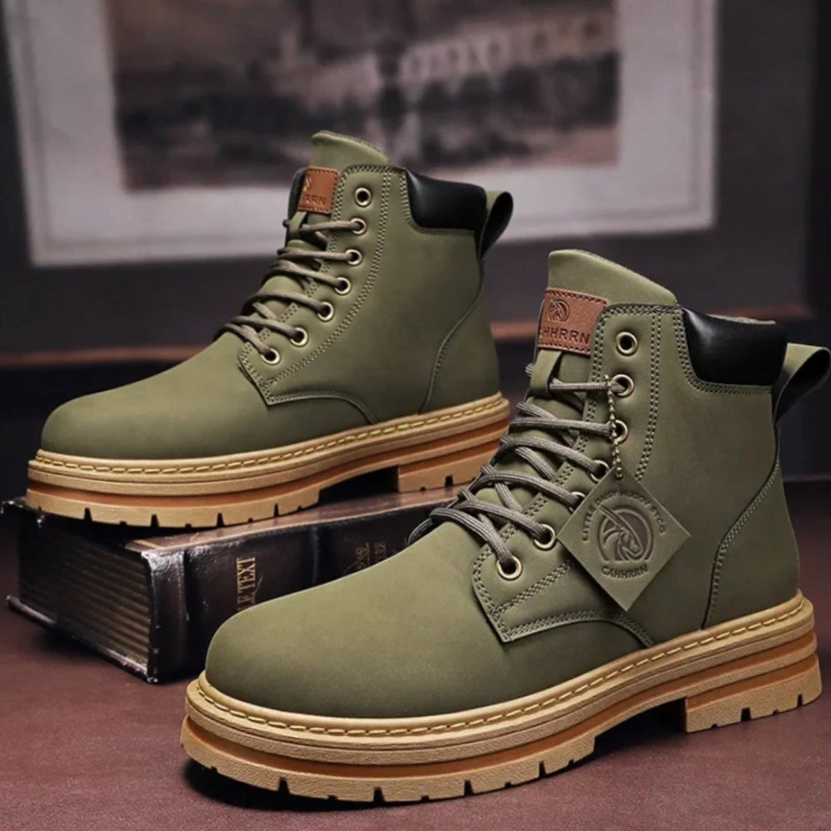 Olive green lace-up ankle boots with tan sole, displayed beside a vintage book