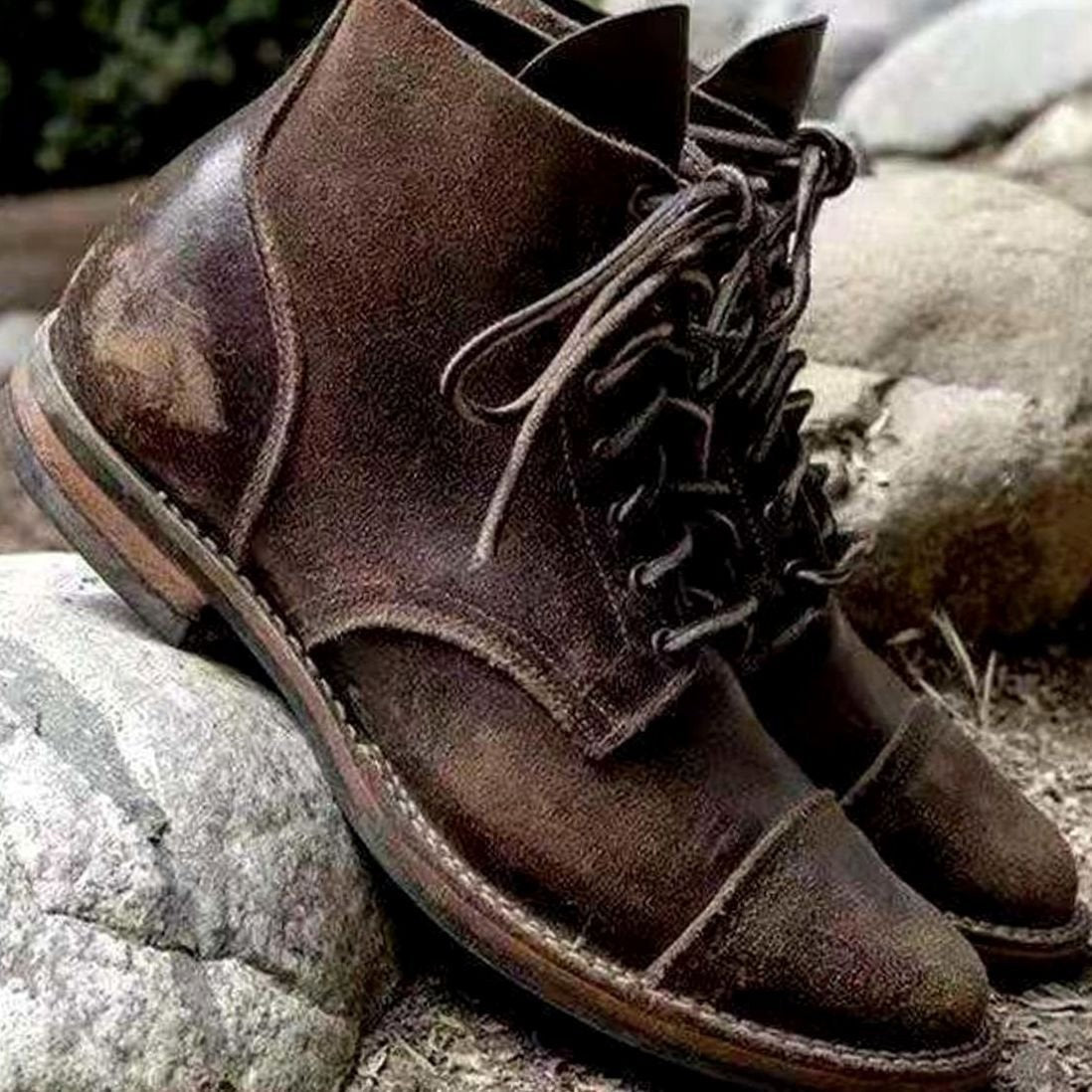 Distressed brown leather lace-up boots with round toe cap, rugged outdoor styling