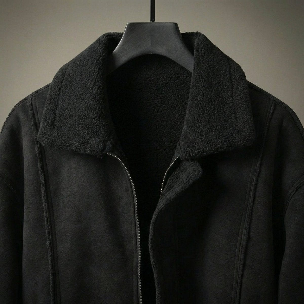 Close-up of black shearling-lined collar on men's suede-effect bomber jacket