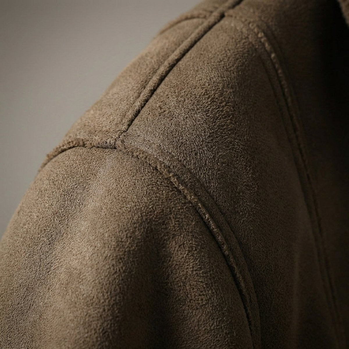 Close-up of brown suede-effect fabric texture and shoulder seam stitching