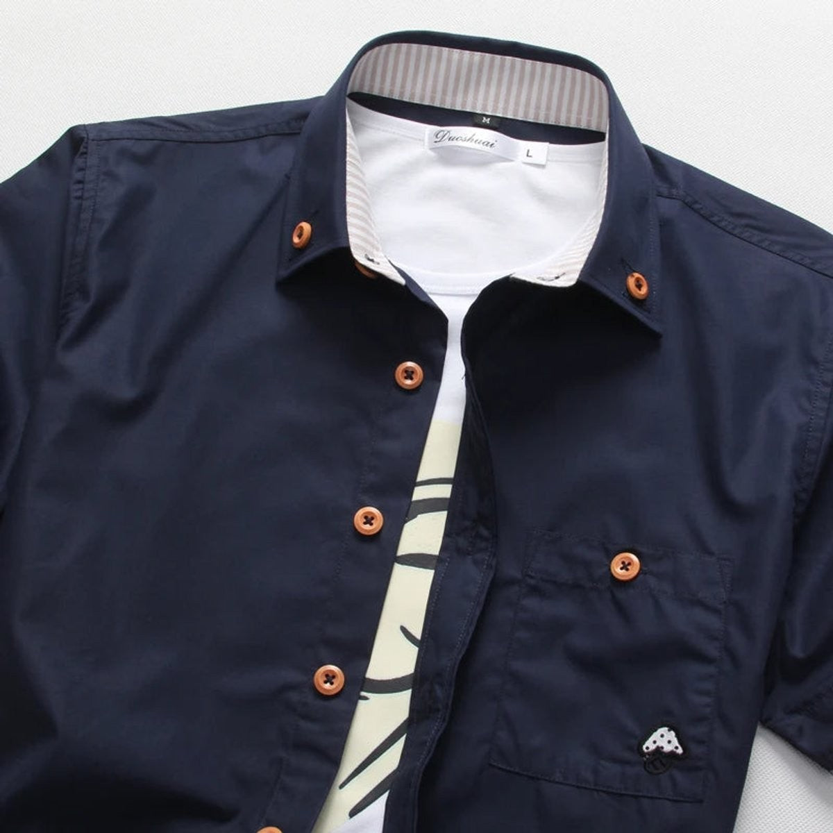 Close-up of navy shirt collar showing wooden buttons and striped inner trim