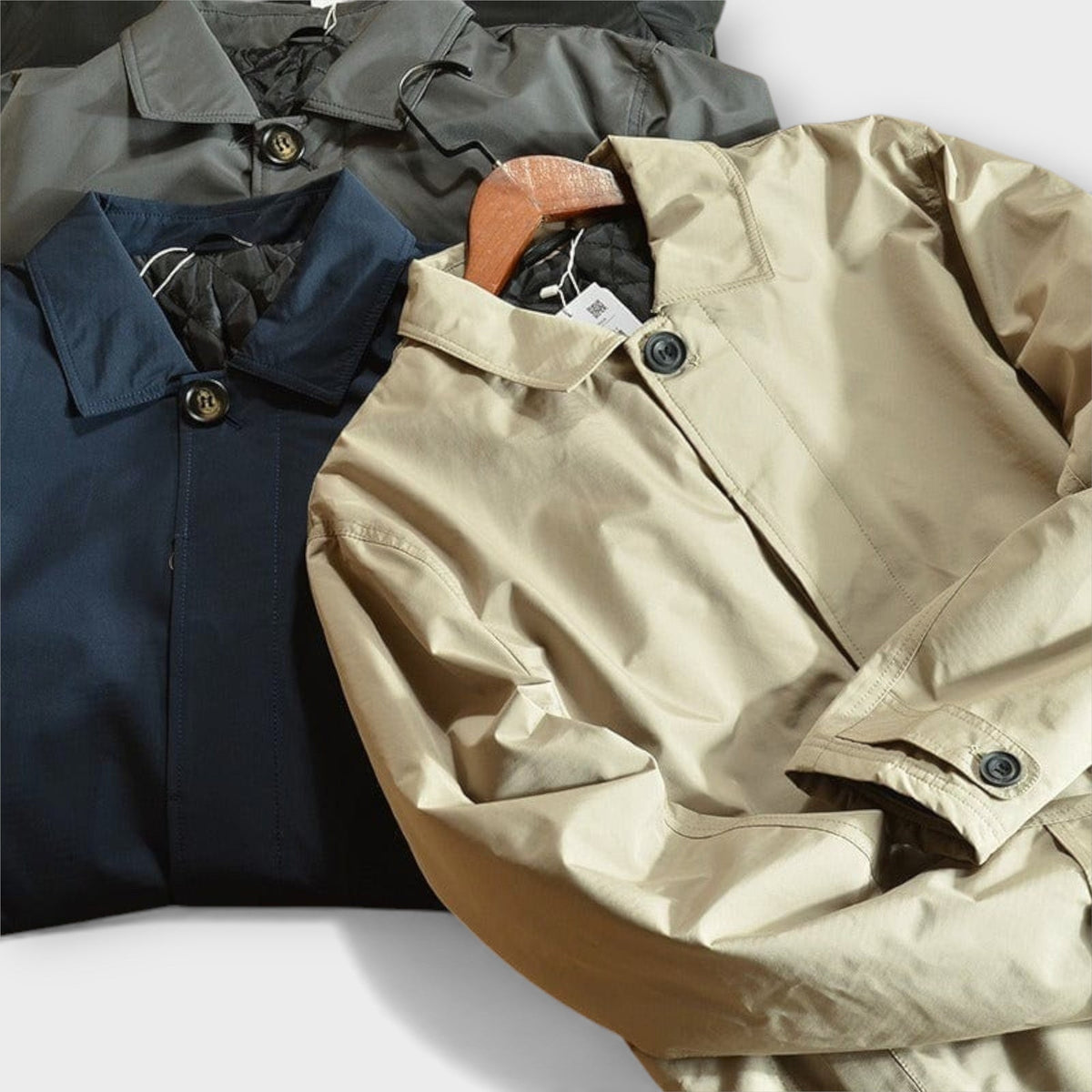 Four mac coats laid together in beige, navy, black and khaki shades