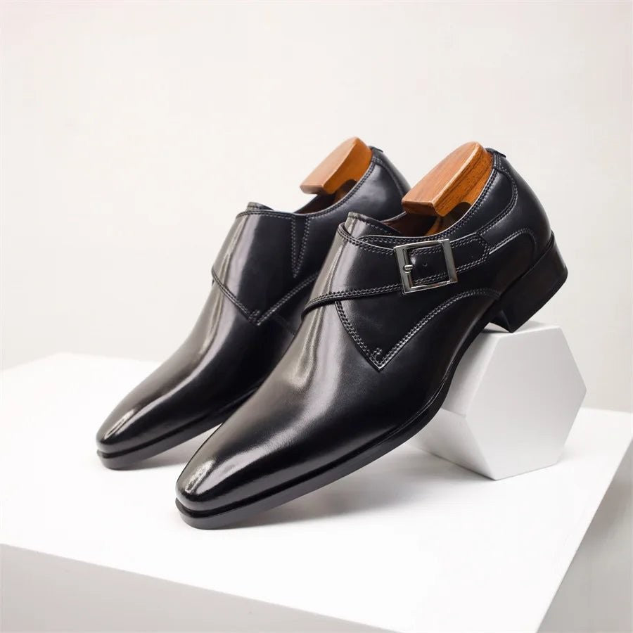 Black leather monk strap shoes resting on white hexagonal stand