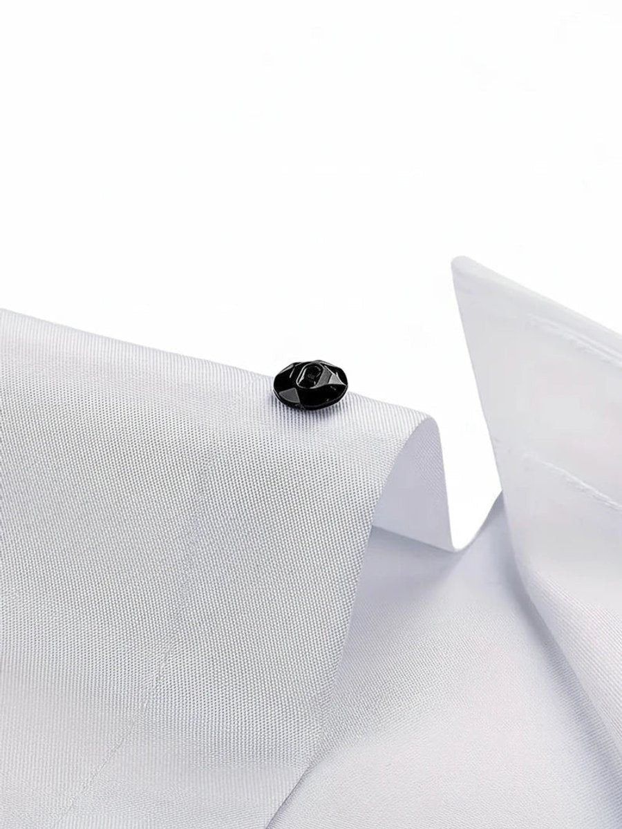 Close-up of faceted black button on white shirt collar fabric
