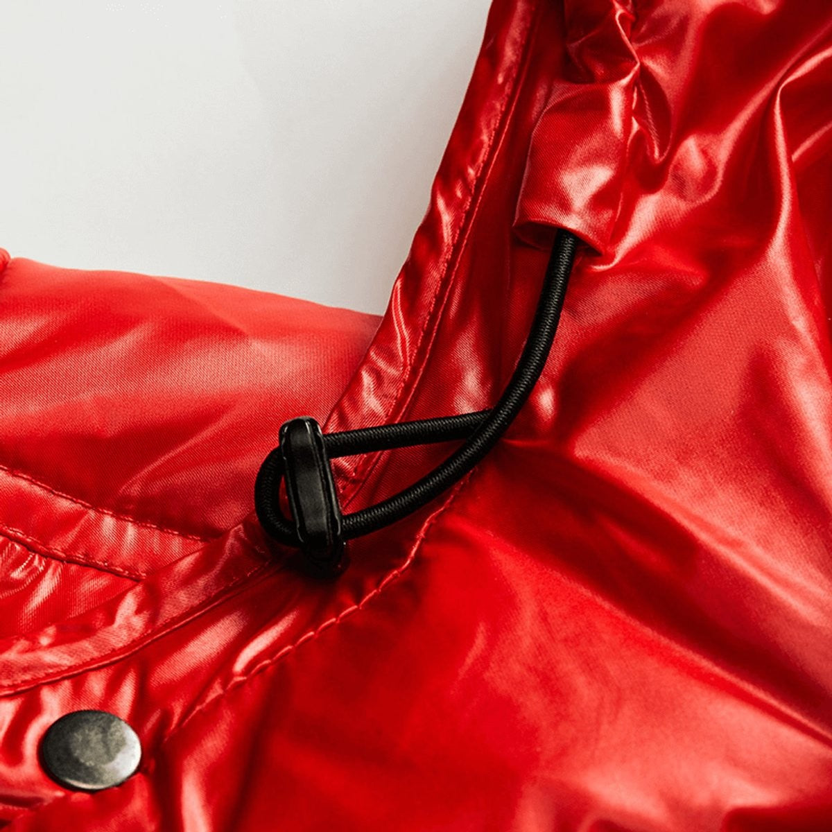 Toggle and drawstring detail on red hooded puffer coat fabric