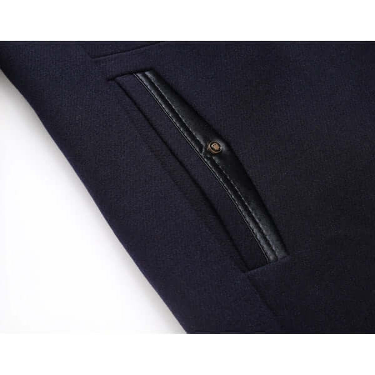 Detail of leather-trimmed pocket on navy men's overcoat