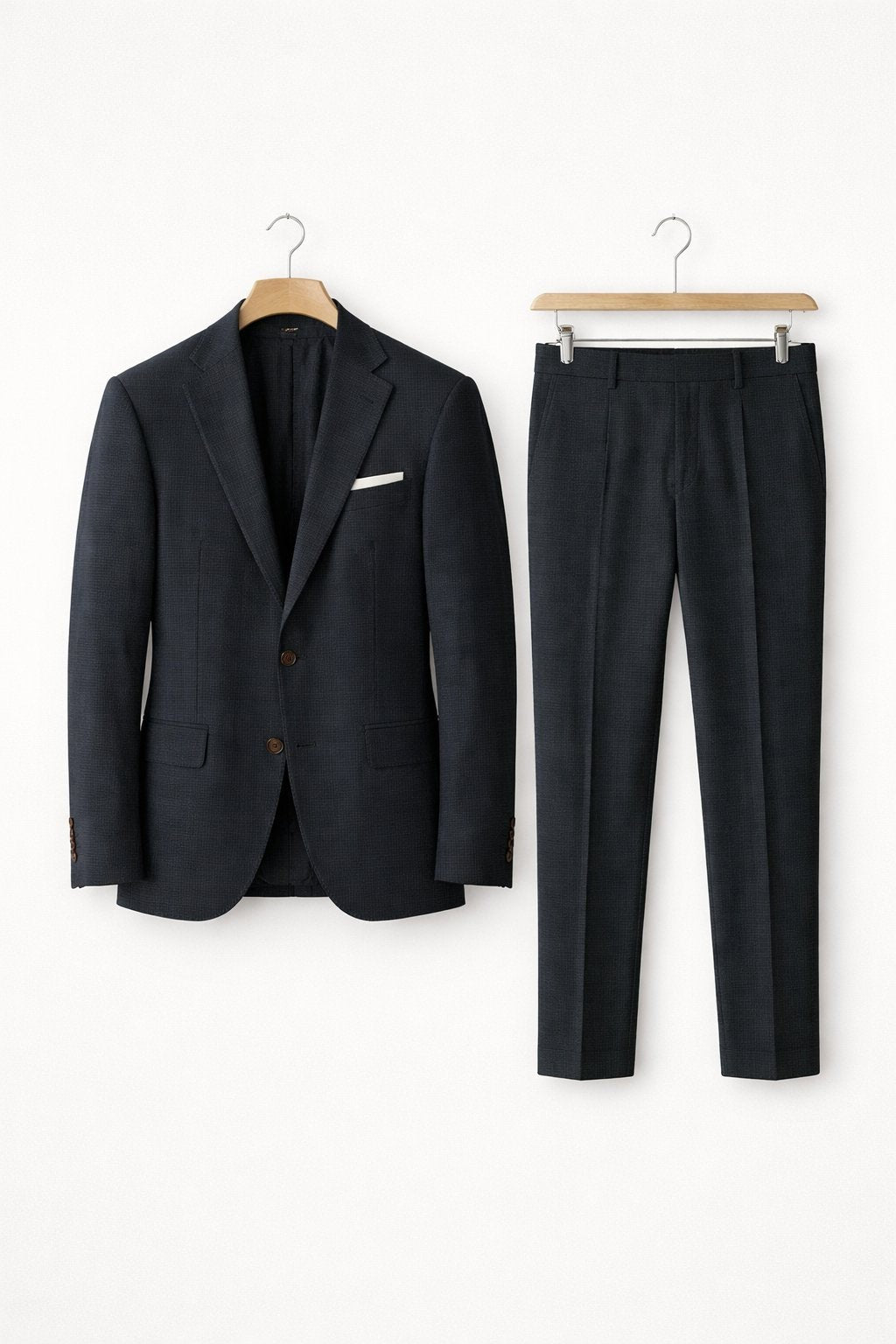 Navy textured suit jacket paired with tailored trousers on hangers
