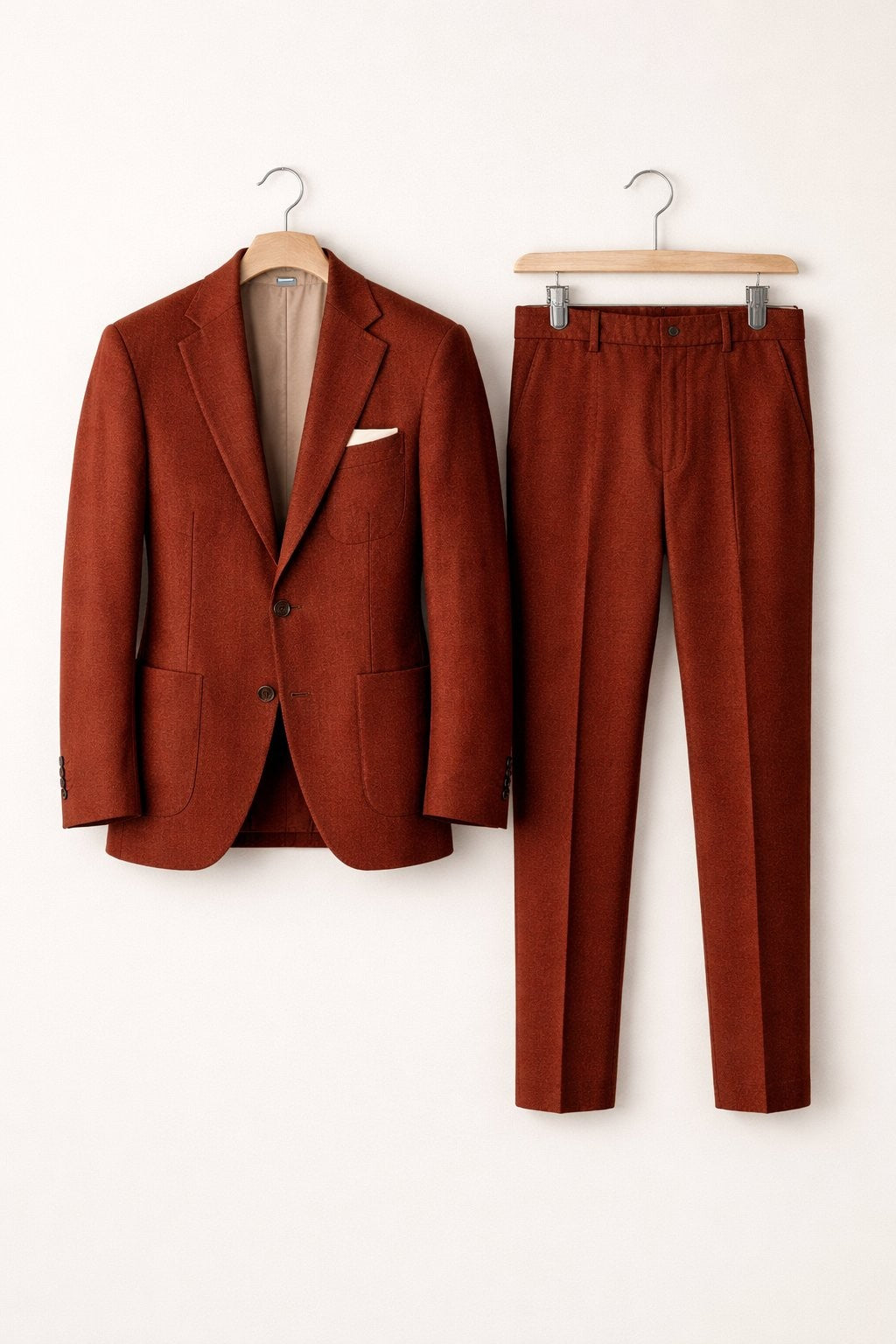 Rust orange textured suit jacket and matching slim trousers on hangers
