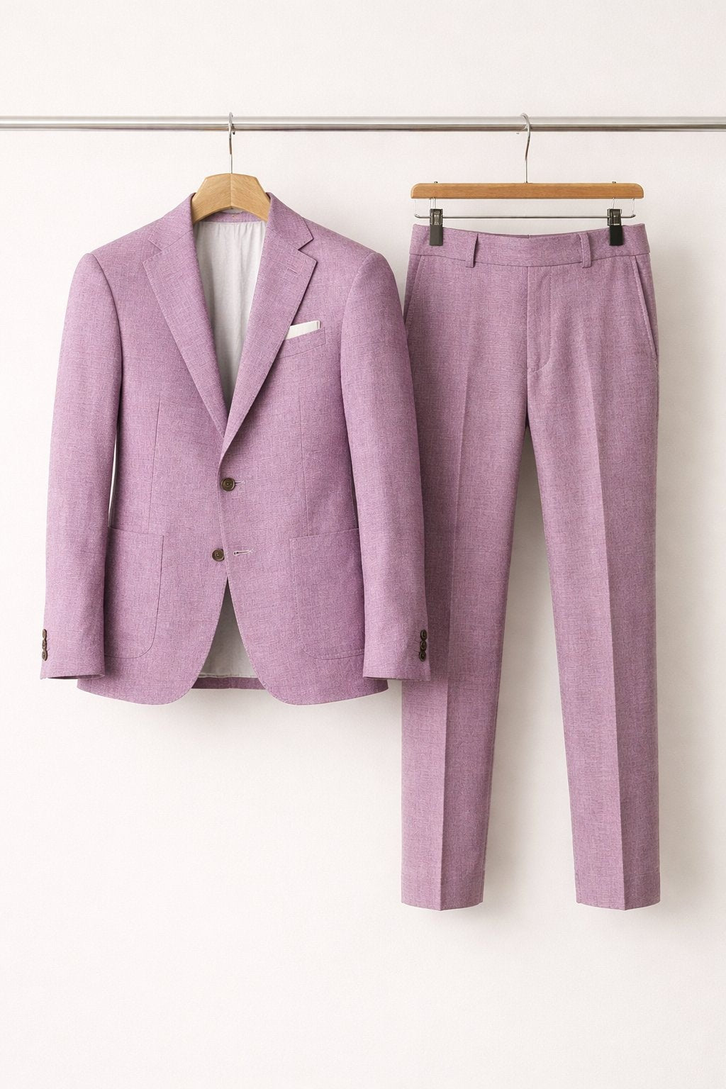 Lilac textured suit jacket and tapered trousers hung on wooden hangers