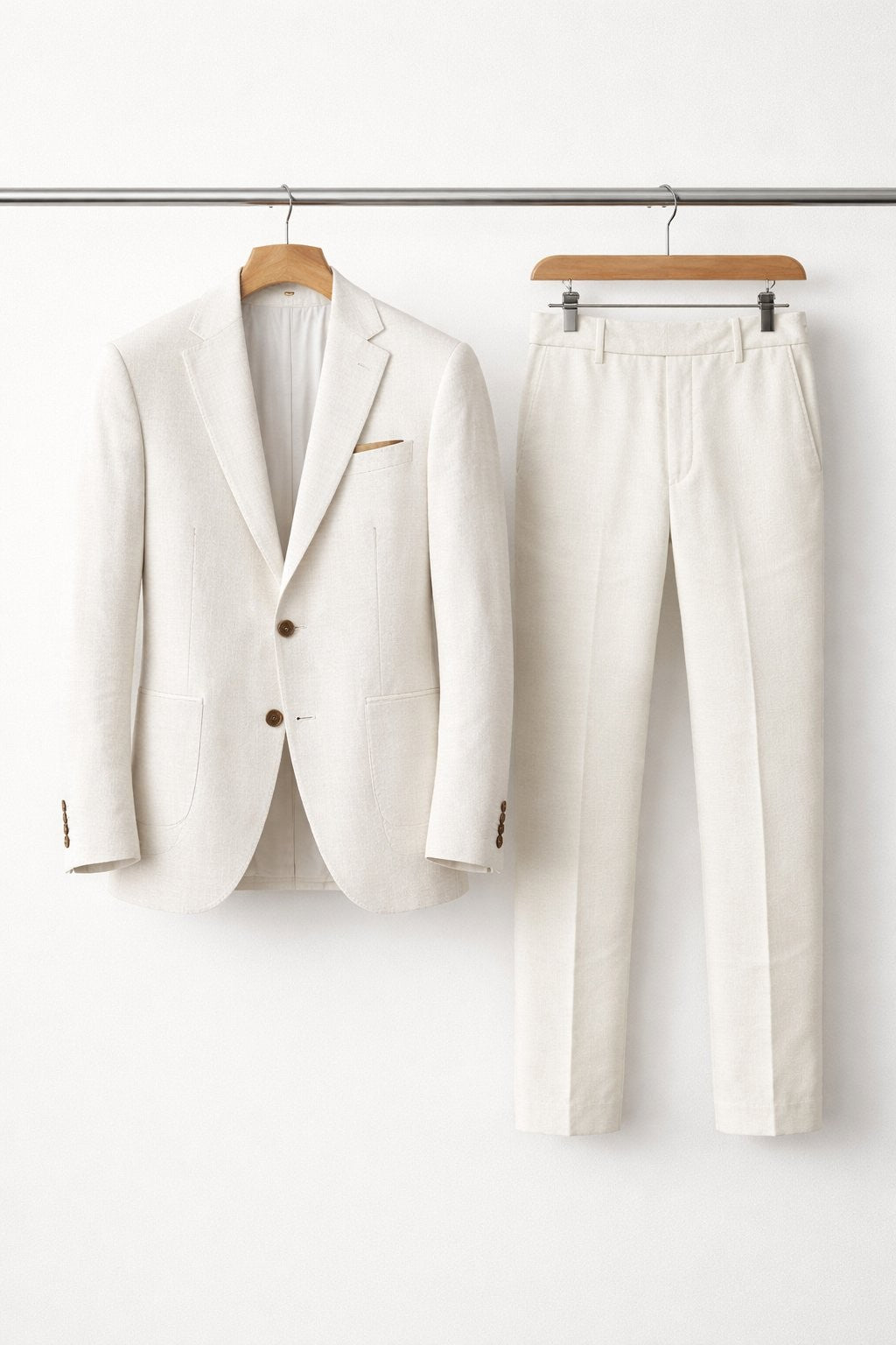 Ivory textured suit jacket and trousers displayed on wooden hangers
