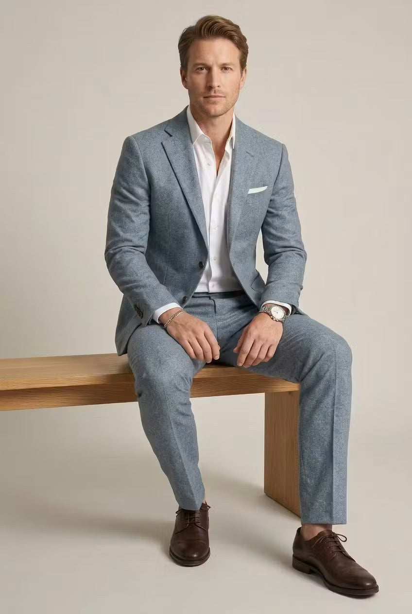 Seated model in pale blue two-piece suit with white pocket square