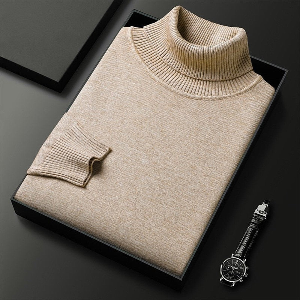 Beige folded turtleneck jumper with ribbed cuffs beside a leather watch