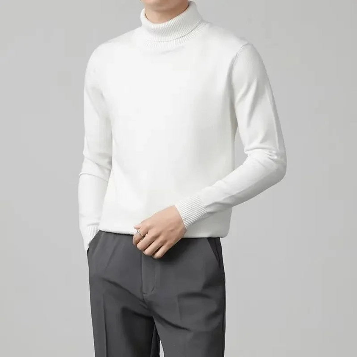 White roll-neck jumper worn with tailored grey trousers, slim-fit knitted style