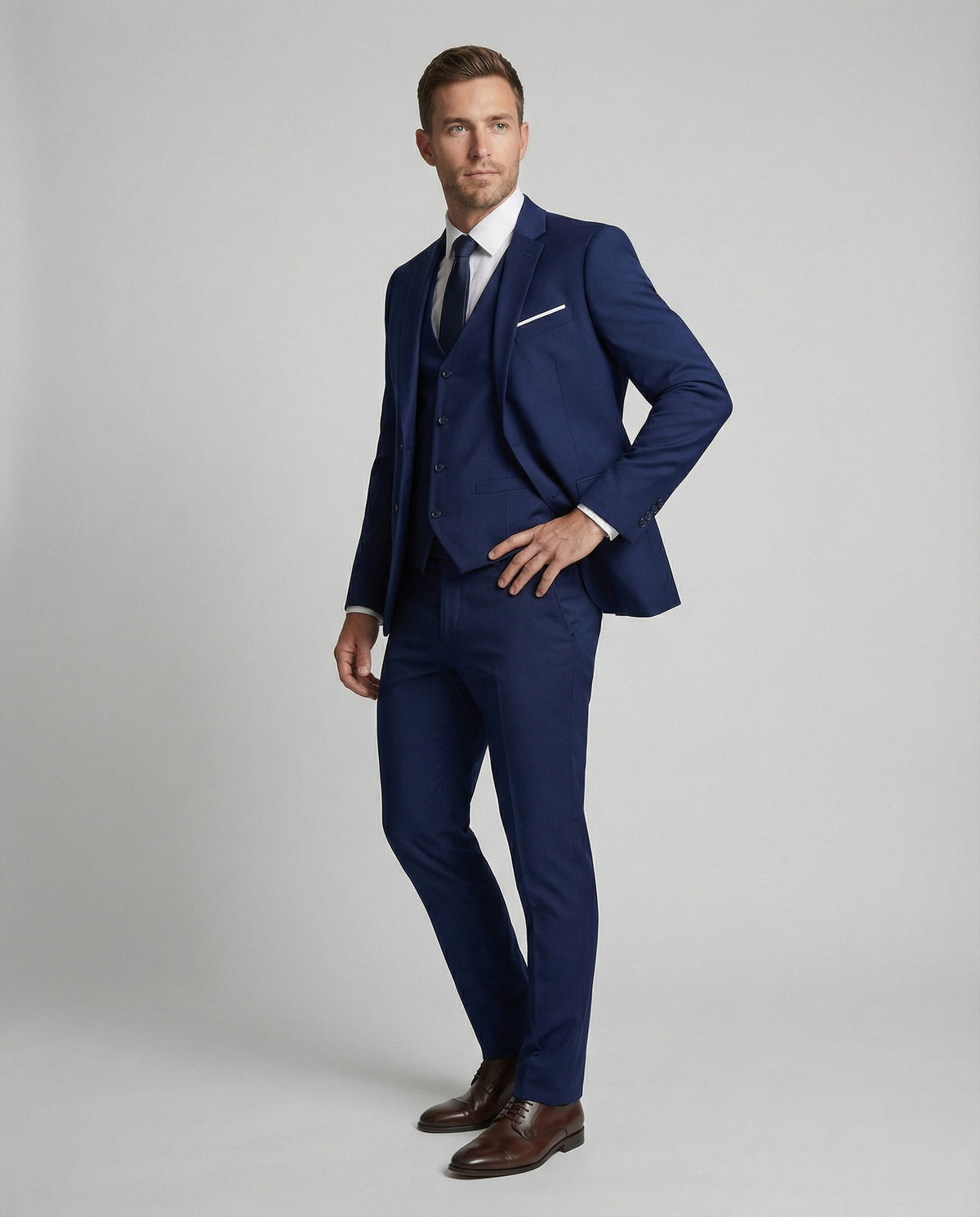 Model wearing navy three-piece suit with pocket square and slim-fit trousers