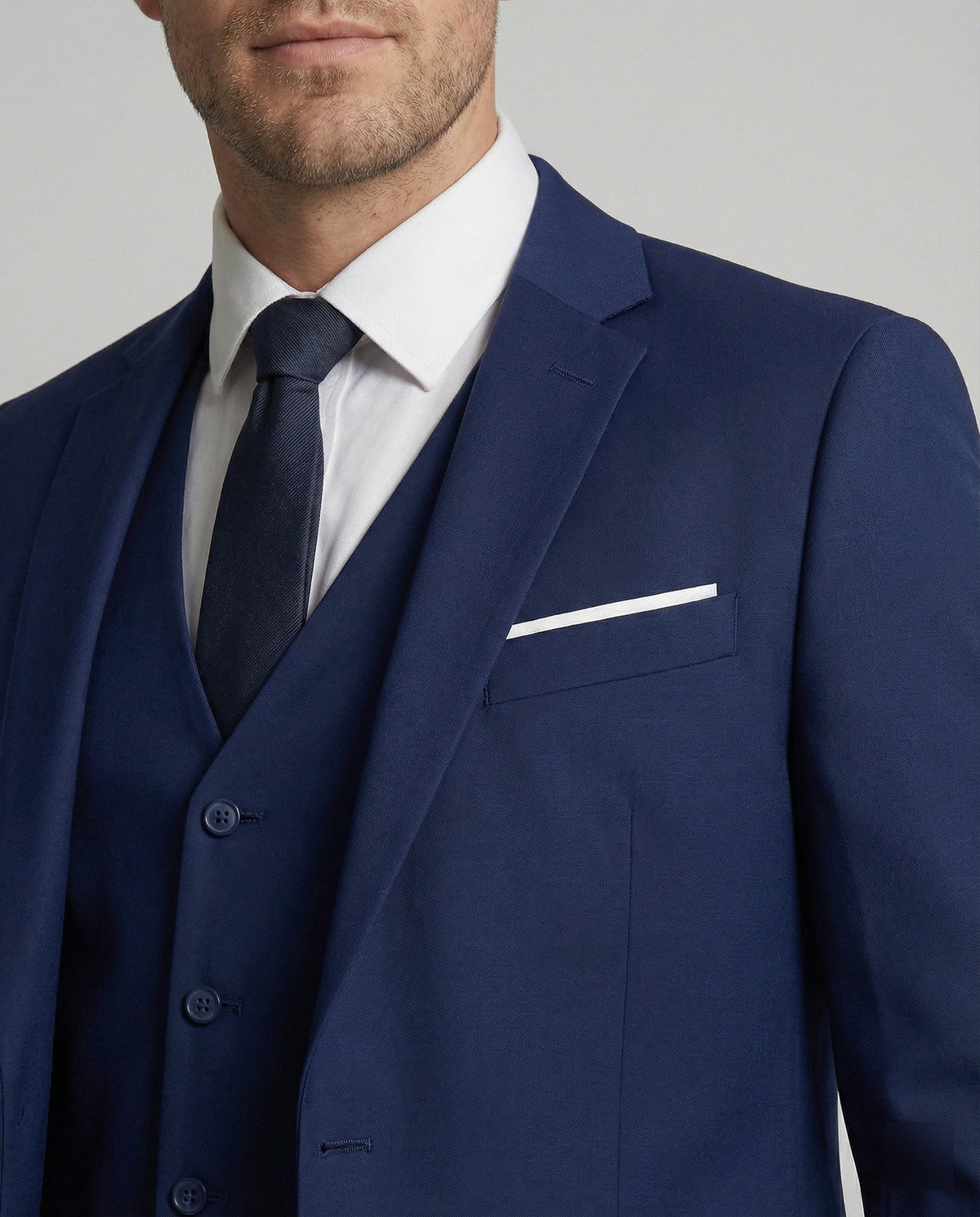 Close-up of navy suit jacket lapel with white pocket square detail