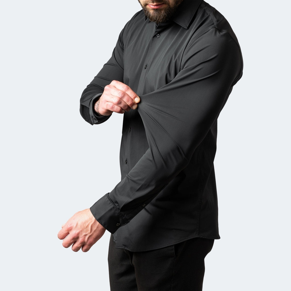 Black stretch dress shirt sleeve stretched to show flexible fit