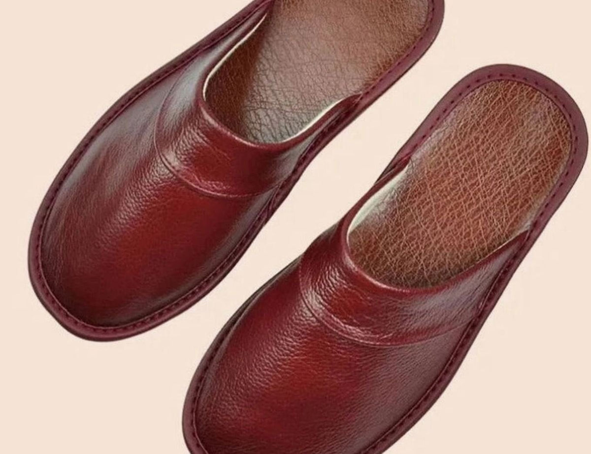 Burgundy leather slip-on slippers with closed toe and stitched trim