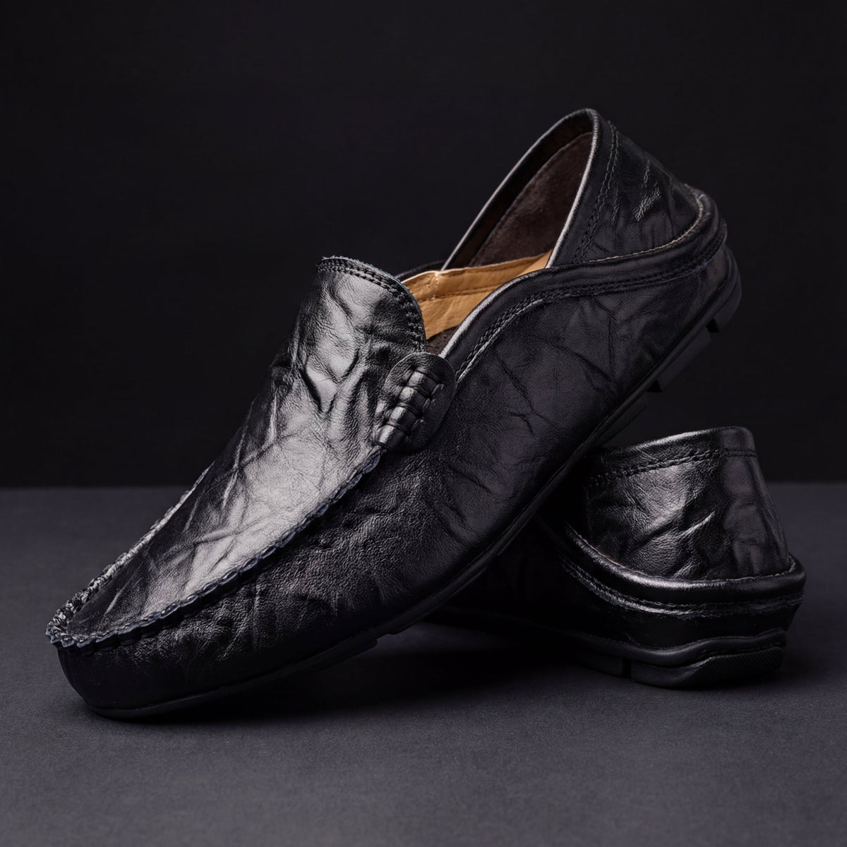 Black leather moccasins with wrinkled finish and rounded driving sole