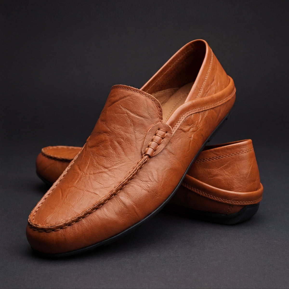 Tan leather moccasins with woven buckle strap and neat topstitching
