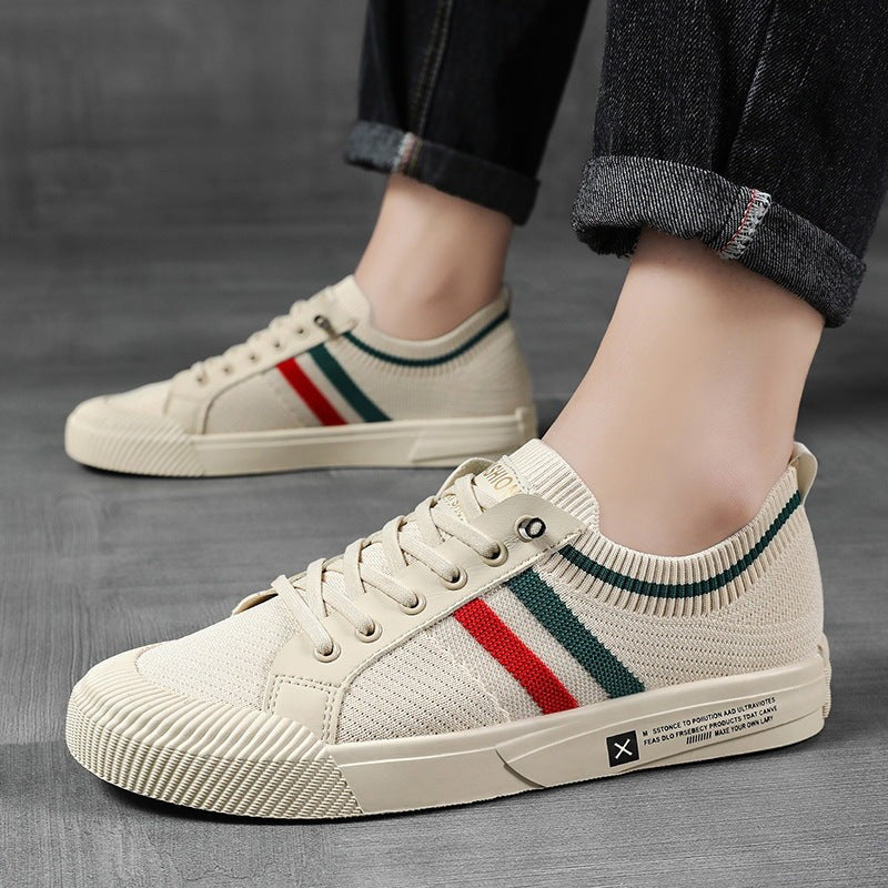 Model wearing beige striped sneakers paired with rolled denim jeans