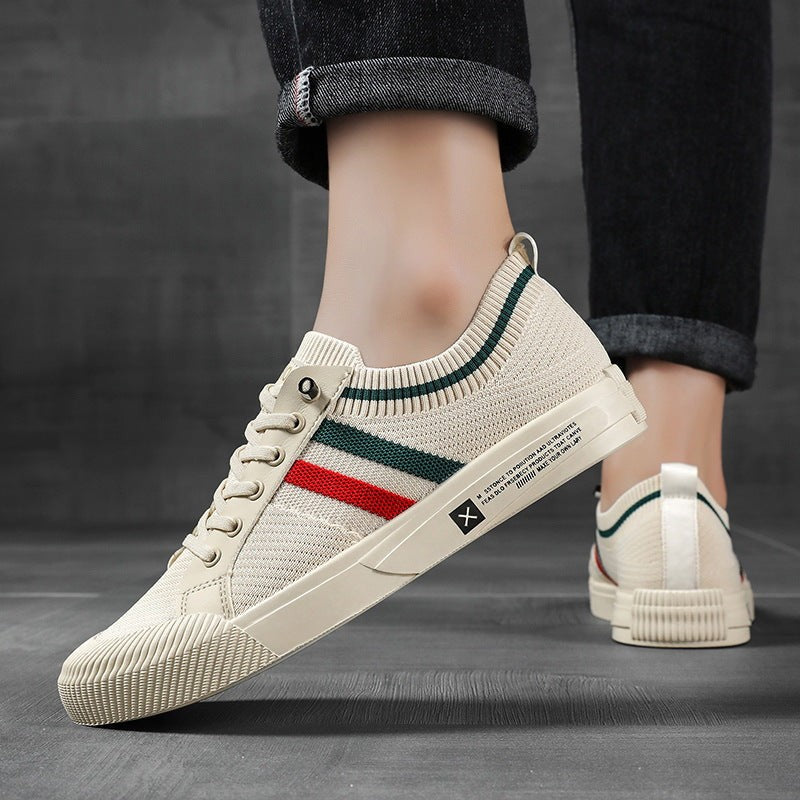 Side view of cream lace-up trainer worn with dark denim