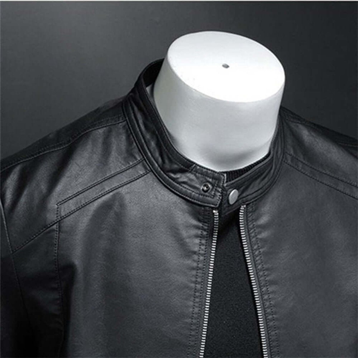Close-up of black faux leather biker jacket collar with popper fastening and zip