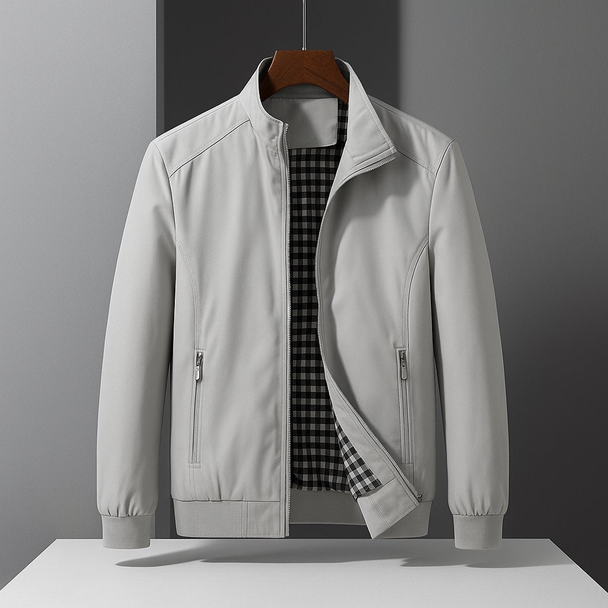 Light grey wind-resistant bomber jacket with front zip pockets, hung neatly