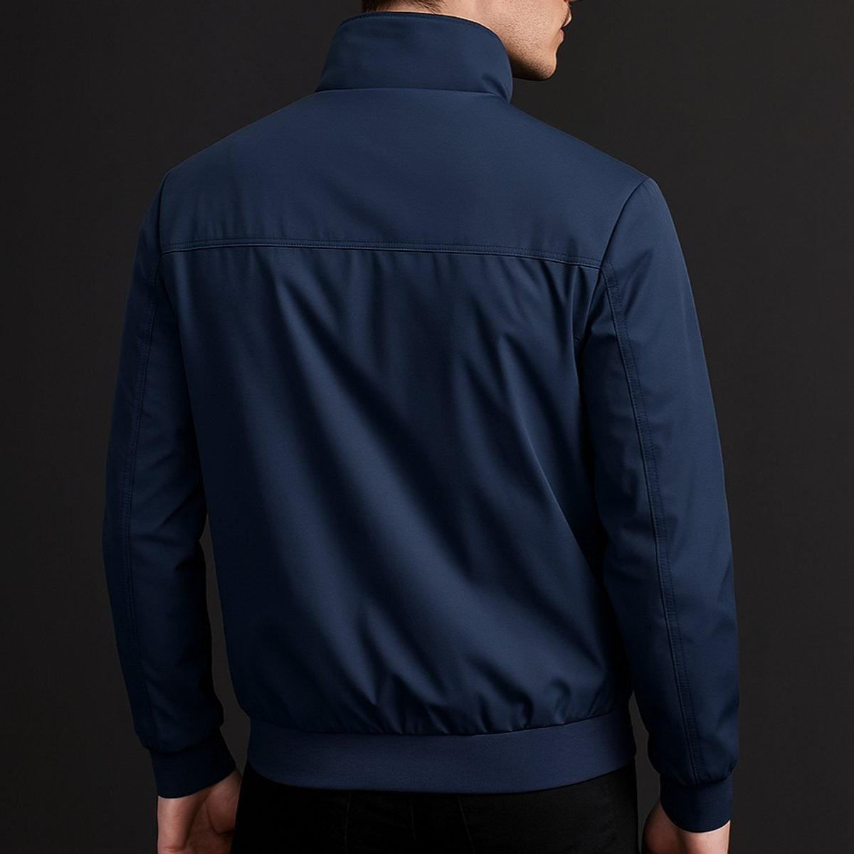 Rear view of navy bomber jacket showing ribbed hem and clean tailoring