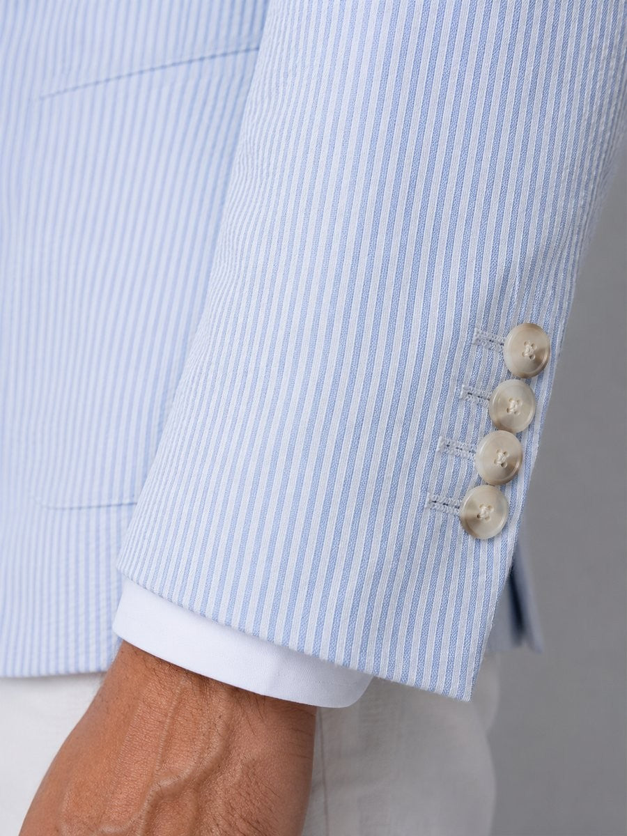 Close-up of blazer cuff buttons on light blue striped seersucker fabric