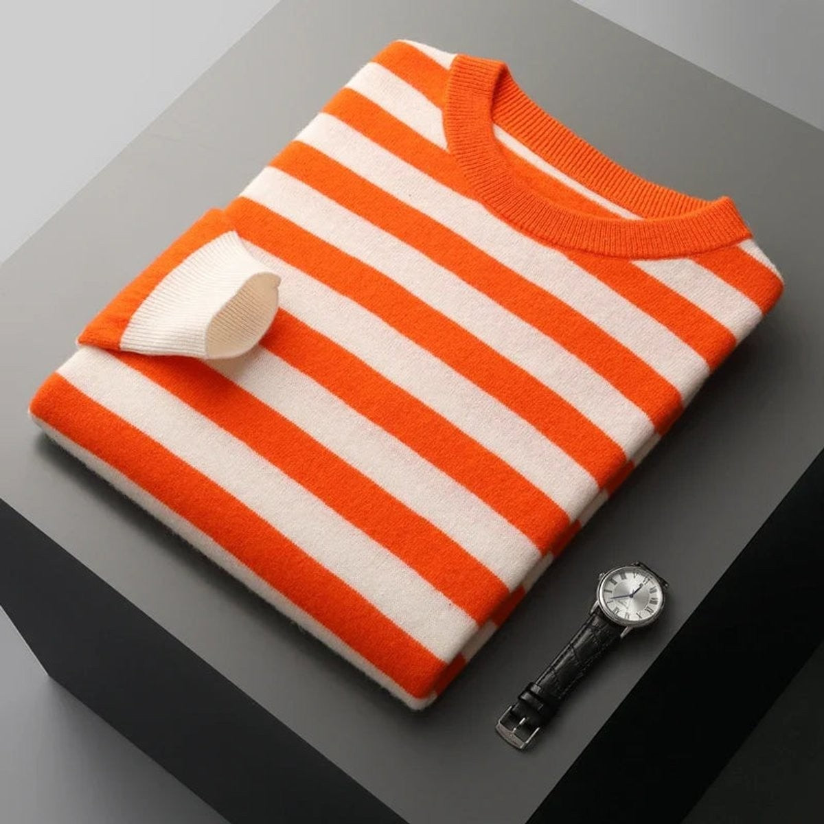 Orange and cream striped pullover folded with contrast ribbed cuffs