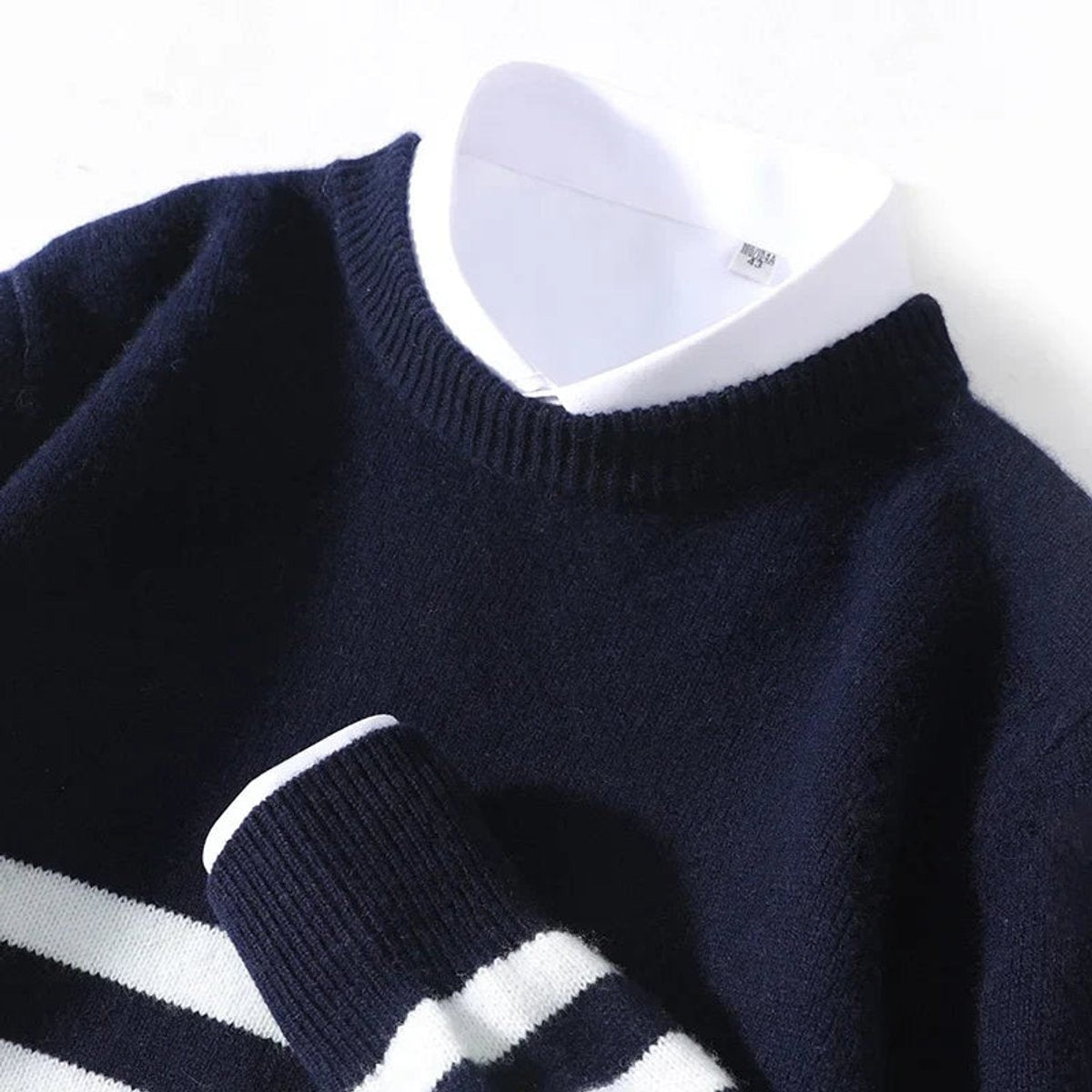 Close-up of ribbed crew neck on navy striped knitted jumper with shirt collar