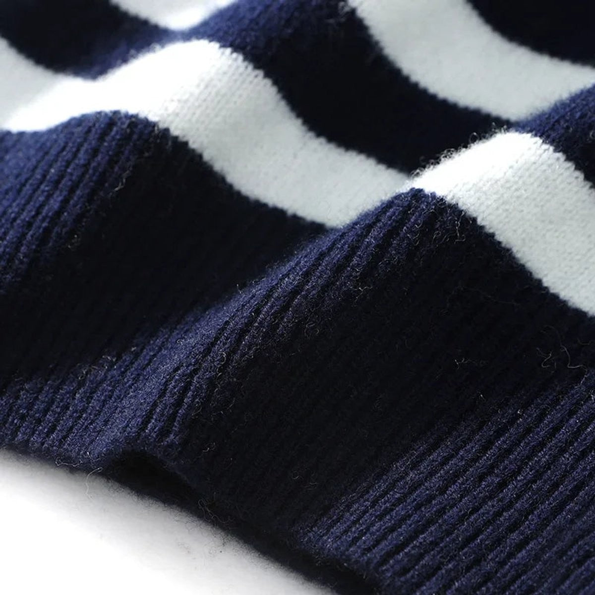 Close-up of ribbed cuff detail on navy and white striped knitted jumper
