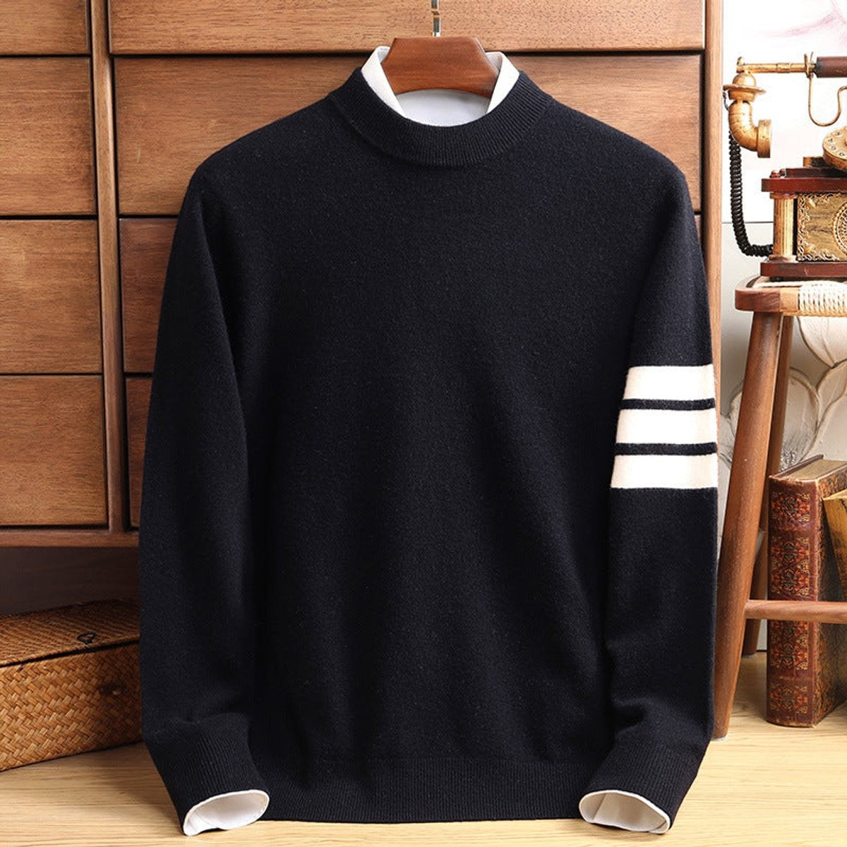 Black knitted pullover showing mock neckline and white striped sleeve trim