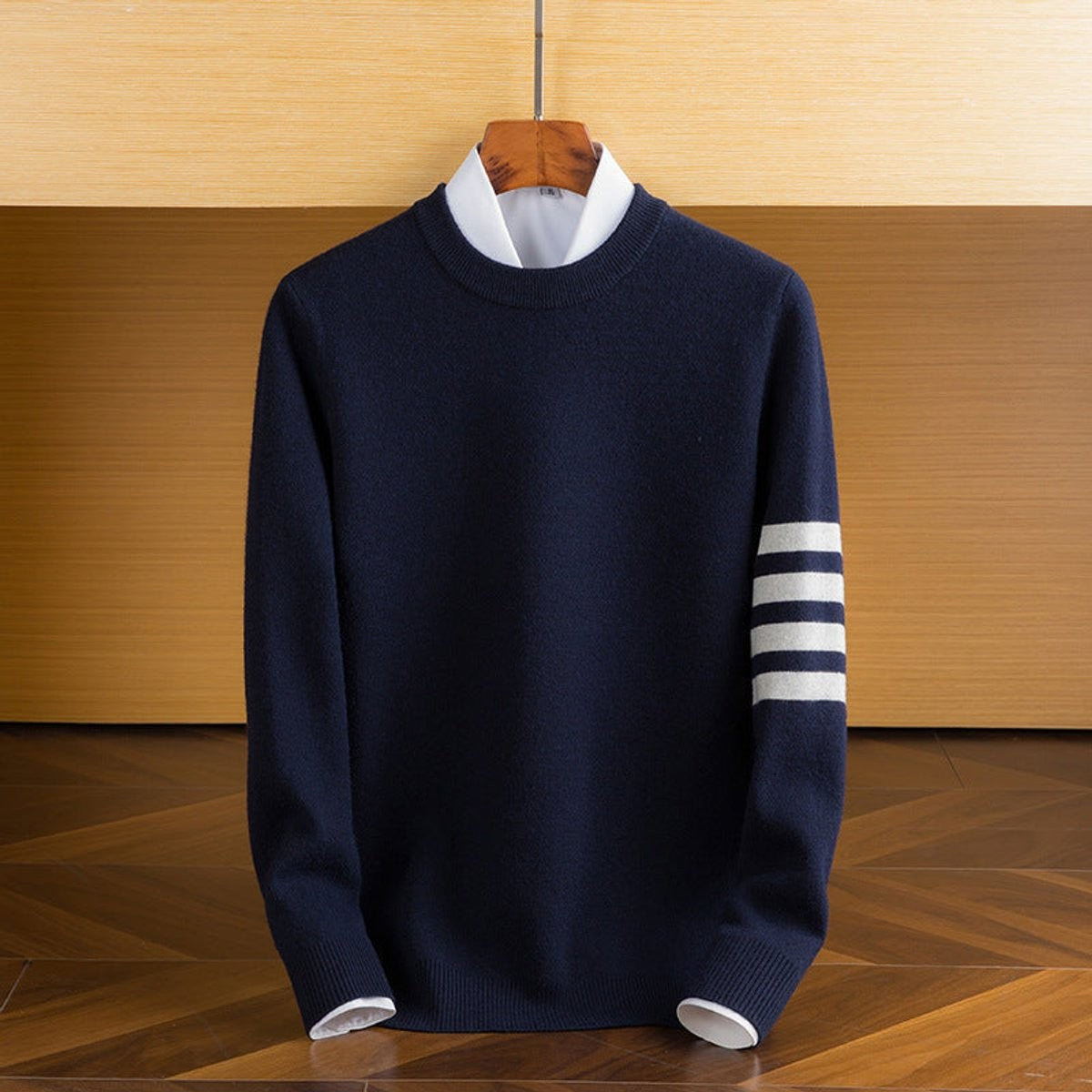 Navy knitted crewneck jumper featuring contrast striped sleeve trim