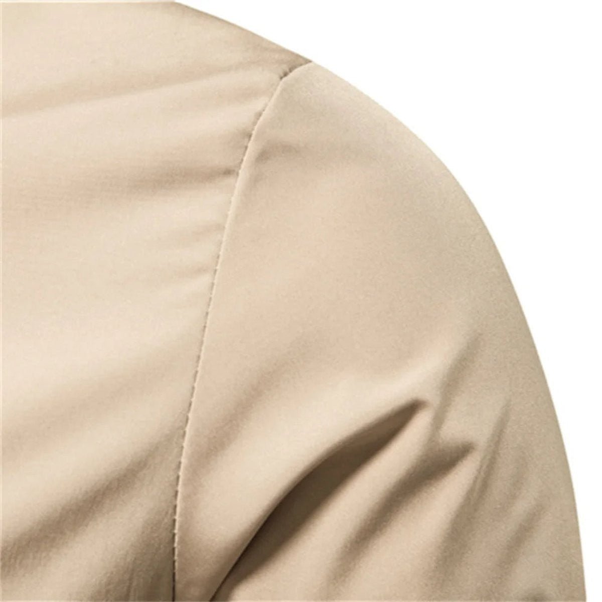 Close-up of beige bomber jacket shoulder seam and smooth fabric finish