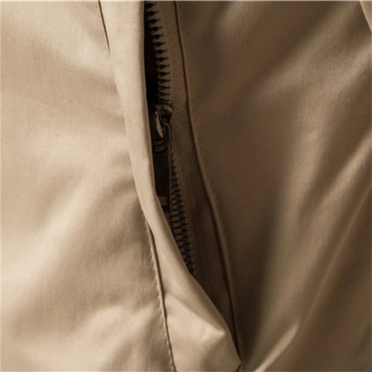 Close-up of zip pull and lining on beige lightweight bomber jacket
