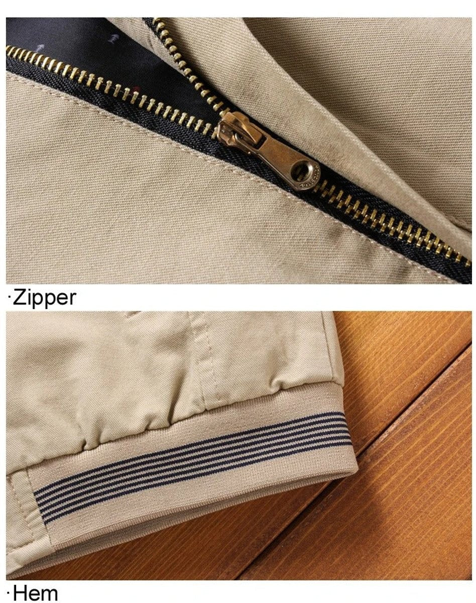 Close-up of bronze zipper and striped ribbed hem on beige bomber jacket