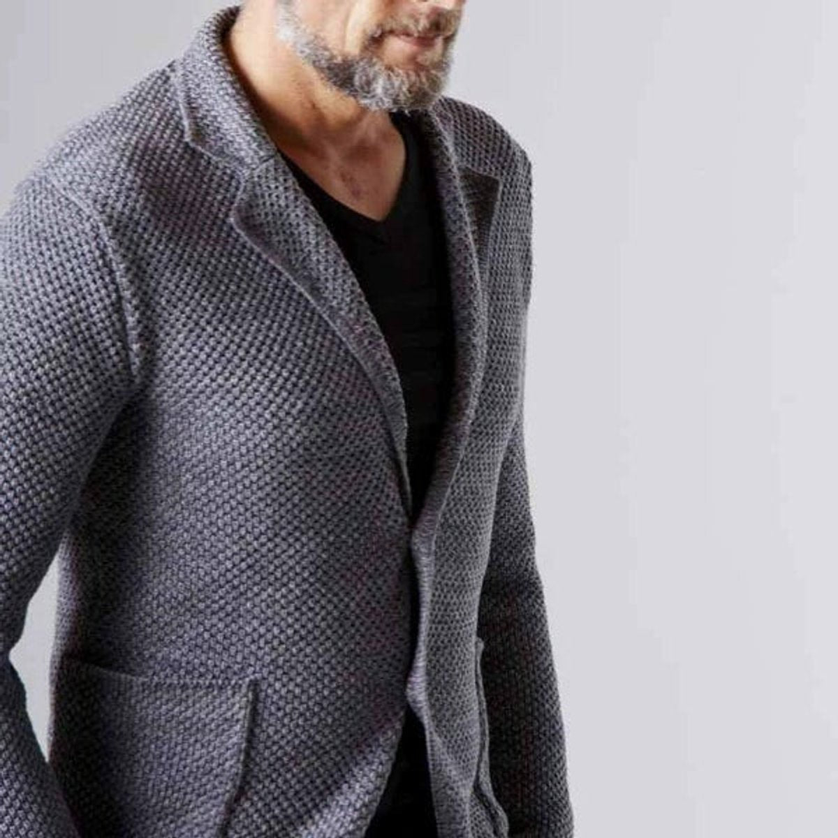 Close-up of grey textured knit blazer showing notch lapel and patch pocket detail