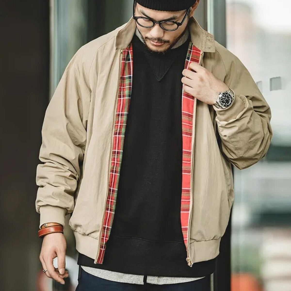 Model styling beige zip-up bomber jacket with tartan trim over jumper
