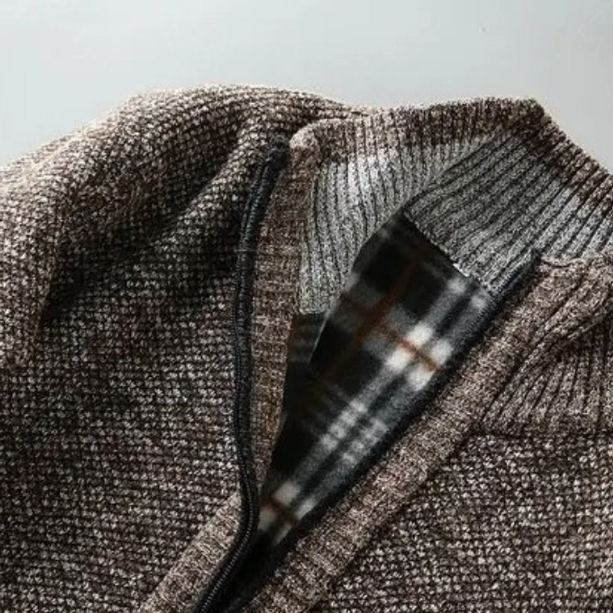 Open collar view showing tartan flannel lining inside knitwear