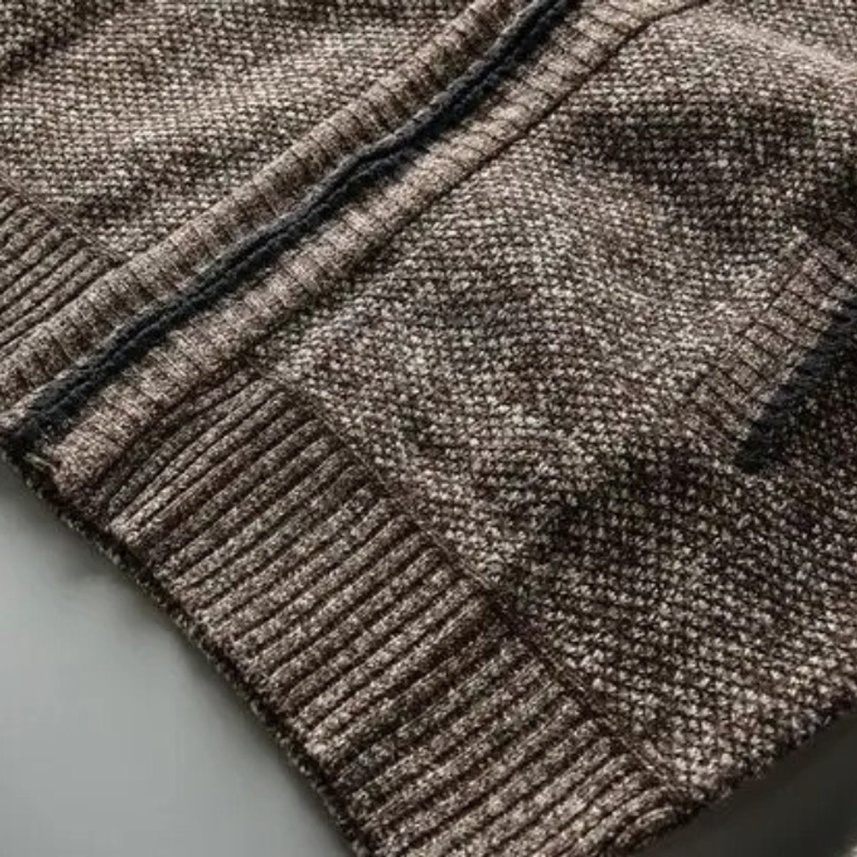 Textured knit cuff and hem detail on brown zip-up jacket