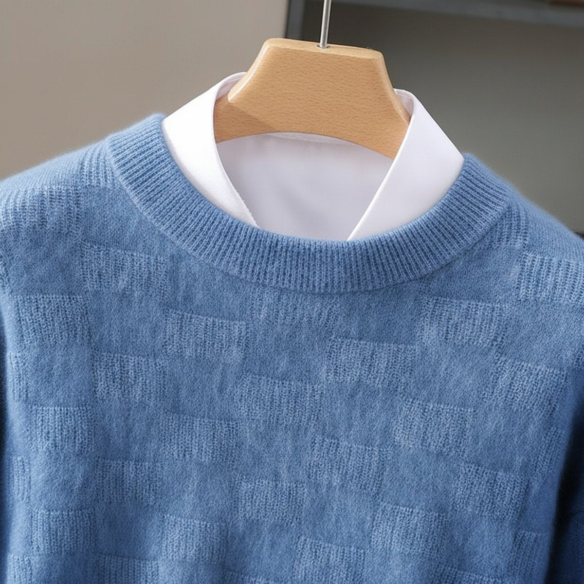 Close-up of blue knitted jumper collar showing ribbed crew neck and textured pattern
