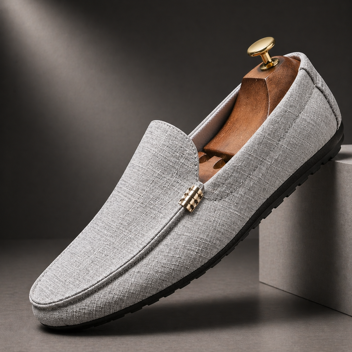 Light grey textured canvas loafer with gold buckle accent, angled view