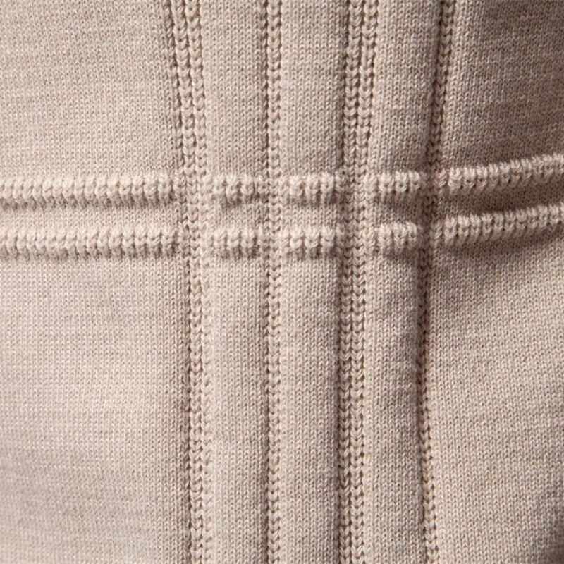 Close-up of beige knit fabric showing crossing ribbed stripe texture