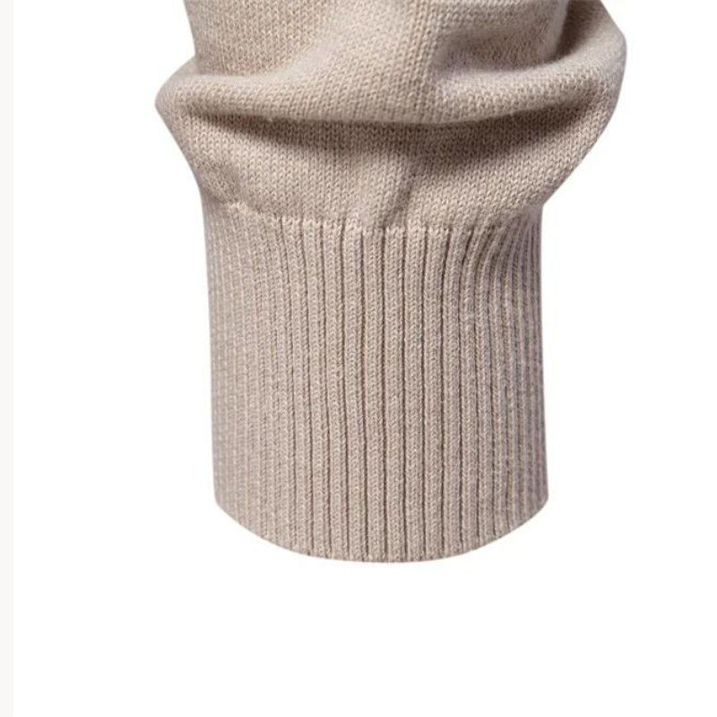 Close-up of ribbed cuff detail on beige knitted jumper sleeve